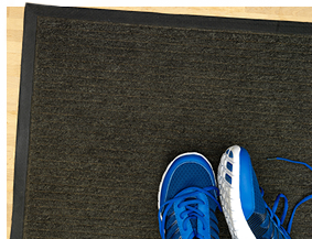 Dark brown floor mat with blue running shoes on top